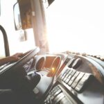 Bestuurder in vrachtwagencabine met zicht op dashboard tijdens sneltransport rit