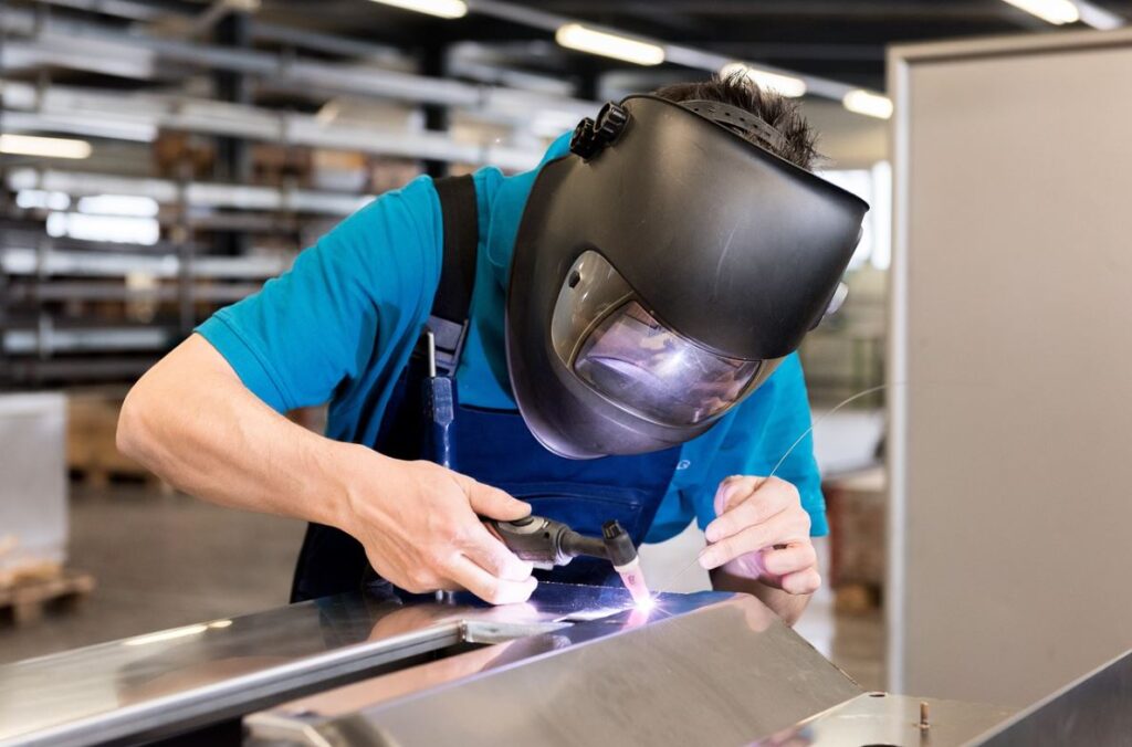 Vakspecialist slijpt metaal met een haakse slijper, vonken vliegen rond bij metaalbewerking Harderwijk