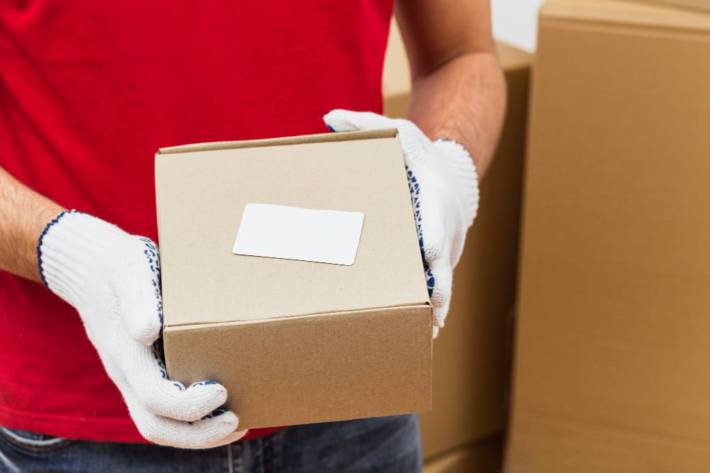 Man heeft met handschoenen een verpakking vast
