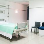 Zorginnovatie zichtbaar in moderne ziekenhuiskamer met leeg bed, infuusstandaard en digitale aansluitingen.
