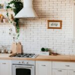 Landelijke keuken met witte kastdeuren, houten werkblad en rustieke details zoals open planken en decoratieve accessoires