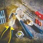 Set handgereedschap op een werkbank, inclusief hamer, tang, schroevendraaier, pluggen en schroeven