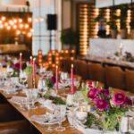 Lange gedekte tafel met bloemen en glazen in sfeervol restaurantinterieur